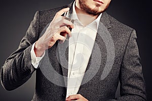 Handsome young man using perfume