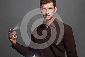 Handsome young man using perfume.perfume bottle and spraying fragrance