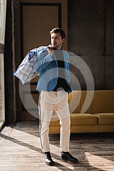 handsome young man with vintage zippered duffle bag on shoulder