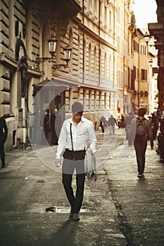 Handsome young man walking in European city street