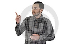 Handsome young man walking and looking to the camera and pointing to the sides showing something on white background.