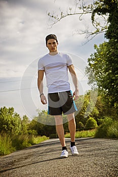 Handsome young man walking and trekking on road