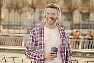 handsome young man wear headphones and smiling while listening music and drinking coffee, morning inspiration.