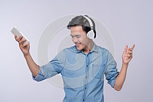 Handsome young man wearing headphones and holding mobile phone w