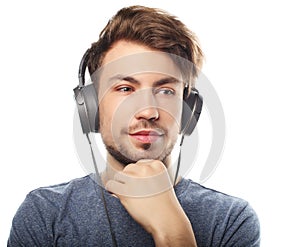 Handsome young man wearing headphones and listening to music.