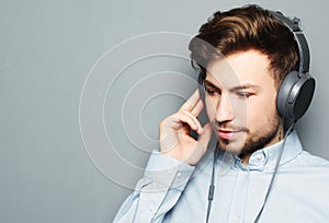 Handsome young man wearing headphones and listening to music.