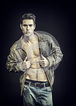 Handsome young man wearing leather jacket on naked torso