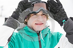 Handsome young man wearing ski goggles outdoors