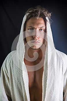 Handsome young man wearing white bathrobe