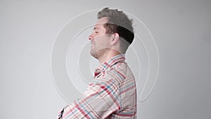 Handsome young man in white shirt smiling. Profile half face view.