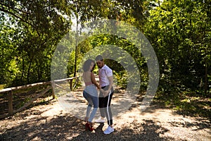 Handsome young man and woman dancing bachata and salsa in the park. The couple dance passionately surrounded by greenery. Dancing