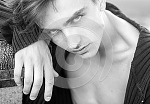 Handsome young man on wooden background looking at camera. Mens fashion concept.