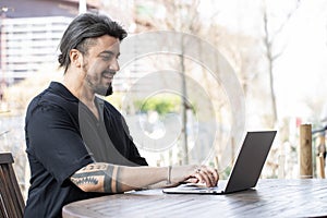 Handsome young man working on a laptop at home