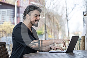 Handsome young man working on a laptop at home