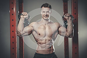 Handsome young man working out in gym kettlebell