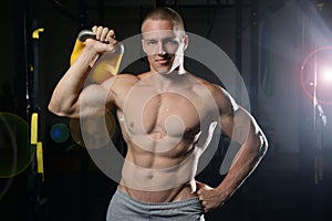 Handsome young man working out in gym kettlebell