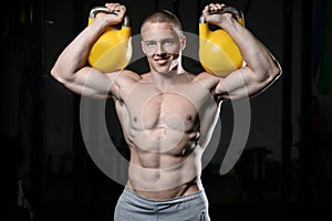 Handsome young man working out in gym kettlebell