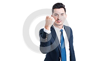 Handsome young manager threatening by showing the fist
