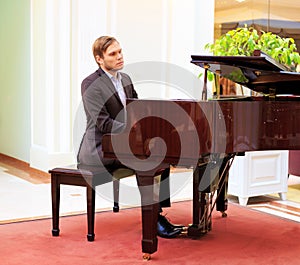 Handsome young men playing piano at the restaurante