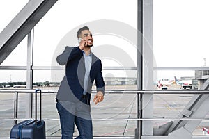 Handsome Young Middle Eastern Man Talking On Mobile Phone At Airport