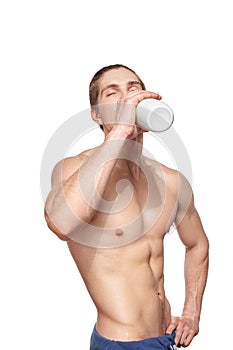 Handsome young muscular athlete drinking with