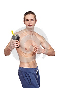 Handsome young muscular athlete holding shaker