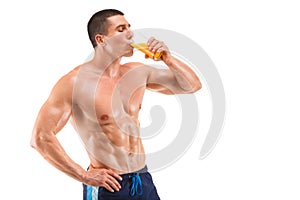 Handsome young muscular man drinking juice isolated on white background