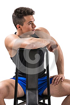 Handsome young muscular man sitting on chair