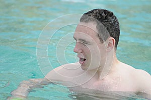 Handsome young muscular man in swimwear on sea background. A man floating and relaxing in the sea.