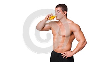 Handsome young muscular sports man drinking juice isolated