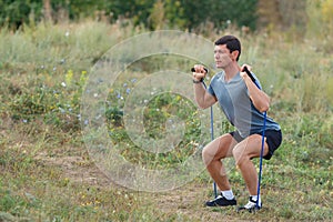 Handsome young muscular sports man exercising outside outdoor with rubber band.