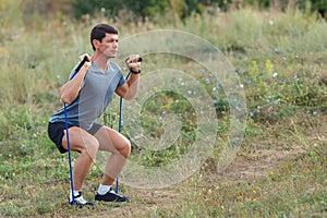 Handsome young muscular sports man exercising outside outdoor with rubber band.