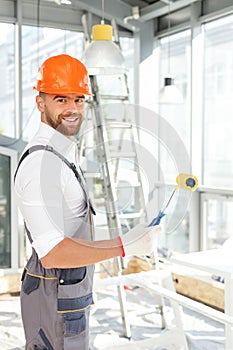 Handsome young painter is working at house