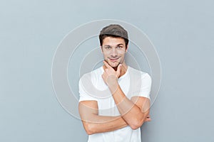 Handsome young pensive man standing and looking up