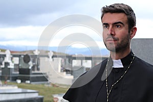 Handsome young priest close up looking away with copy space
