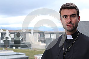 Handsome young priest close up looking away with copy space