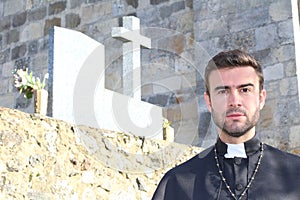 Handsome young priest close up looking seductive with copy space