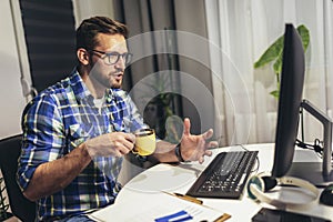 Young programmer working at home late in evening
