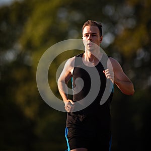 Handsome young runner jogging outdoors