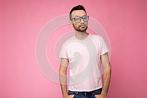 Handsome young self-confident brunet unshaven man wearing white t-shirt for mockup and stylish optical glasses isolated