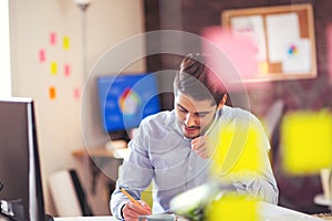 Handsome young smiling businessman working with documents