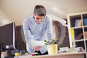 Handsome young smiling businessman working with documents