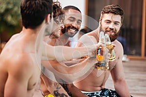 Handsome young smiling men having fun in swimming pool