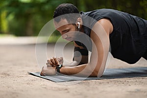 Handsome young sporty black man set his fitness tracker