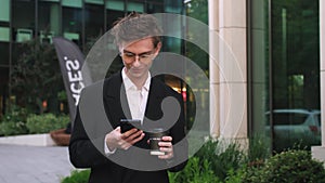 Handsome young Startup Businessman in Glasses using mobile Phone. Young man texting Messages, cheating on his Smartphone