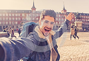 Handsome young student tourist man happy and excited taking a selfie in Madrid, Spain