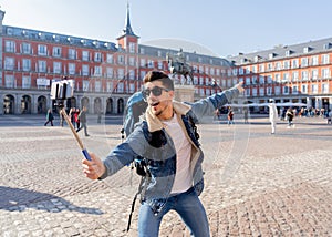 Handsome young student tourist man happy and excited taking a selfie in Madrid, Spain