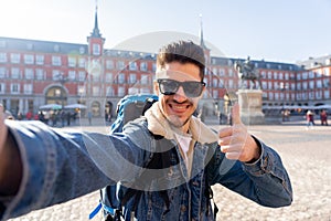 Handsome young student tourist man happy and excited taking a selfie in Madrid, Spain