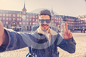 Handsome young student tourist man happy and excited taking a selfie in Madrid, Spain