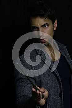 Handsome young wizard holding a magic wand